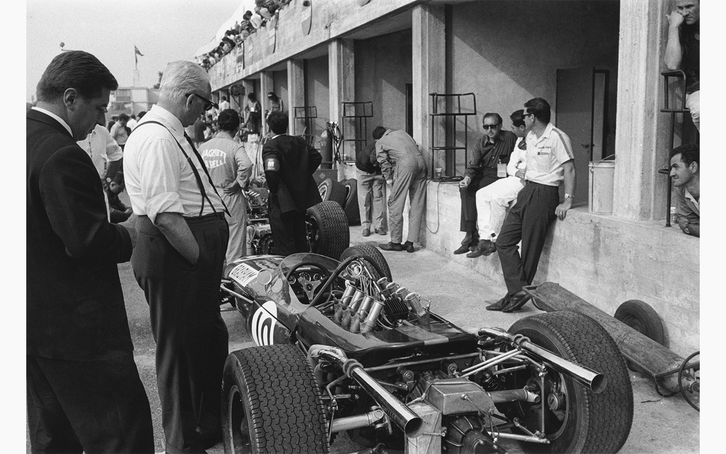 Итальянский автогонщик и бизнесмен Энцо Феррари смотрит на Brabham-Repco во время Гран-при Италии в Монце, 4 сентября 1966 года